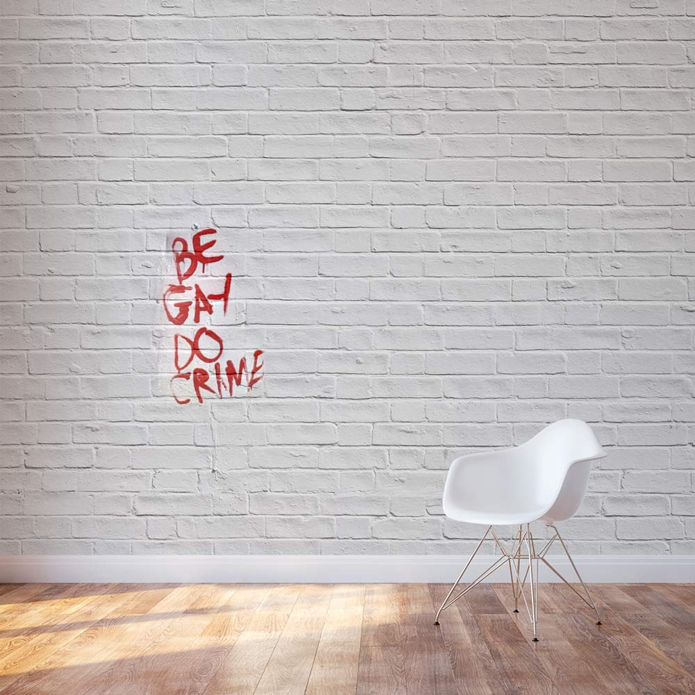 A room with a white wall with graffiti blended into part of it